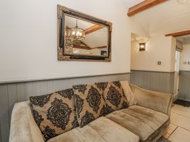 A living room with a sofa and mirror at The Dove Cot in Ambleside