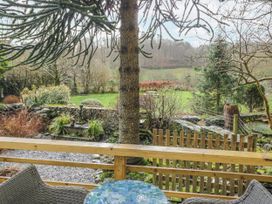 A garden view with a tree and stone wall at The Dove Cot in Ambleside