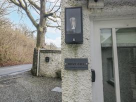 A lamp and sign on a wall with a mailbox nearby at The Dove Cot in Ambleside