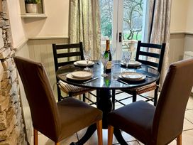 A dining room with a round table set for a meal at The Dove Cot in Clappersgate near Ambleside