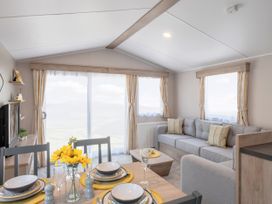 A living room with a couch and dining table at 554 Pentreath View in Perranporth