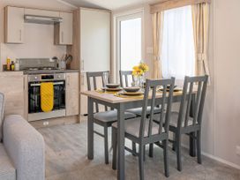 A kitchen/dining area with a dining table and stove at 554 Pentreath View Perranporth
