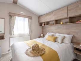 A bedroom with a bed and decorative items at 554 Pentreath View in Perranporth