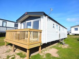 A caravan with a deck and steps at 554 Pentreath View Perranporth
