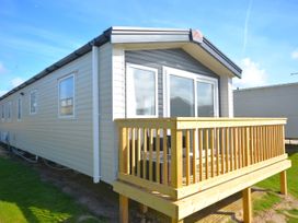 A mobile home with a deck and windows at 554 Pentreath View in Perranporth