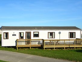 A mobile home with a deck and windows at 457 Pentreath View Perranporth