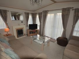 A living room with a sofa and television at 457 Pentreath View Perranporth