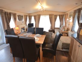 A living room with a dining area and a sofa at 457 Pentreath View in Perranporth