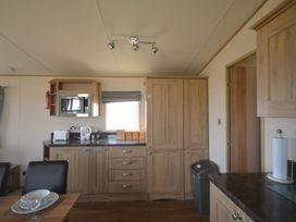 A kitchen with microwave and cabinets at 457 Pentreath View Perranporth