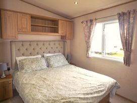 A bedroom with a bed and window at 457 Pentreath View in Perranporth