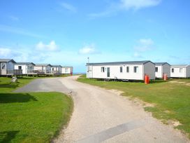 An outdoor area with caravans and a road at 457 Pentreath View Perranporth