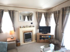 A living room with a television and fireplace at 457 Pentreath View Perranporth
