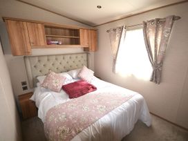 A bedroom with a bed and cabinets at 457 Pentreath View, Perranporth