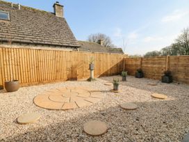 A garden with gravel, stone slabs, and planters at Paddock View Stow-On-The-Wold