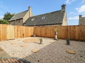 A garden with gravel and plant pots at Paddock View in Stow-On-The-Wold