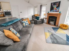 A living room with a sofa and armchair at Nevaeh Lodge in Longframlington
