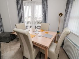 A dining room with a table and chairs at Nevaeh Lodge Longframlington
