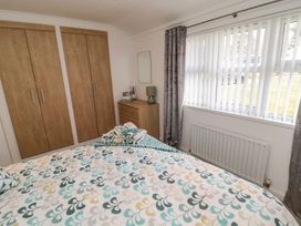 A bedroom with a bed and wardrobe at Nevaeh Lodge Longframlington