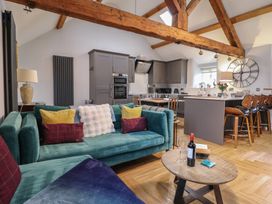 A living room with a sofa and kitchen area at The Old Cartshed | Yr Hen Gwt Cart Abergele