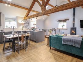 A living room with a dining table and a kitchen island at The Old Cartshed | Yr Hen Gwt Cart Abergele