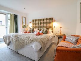 A bedroom with a bed and a chair at The Old Cartshed | Yr Hen Gwt Cart in Abergele