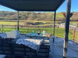 An outdoor patio with a sofa and table at The Old Cartshed | Yr Hen Gwt Cart, Llangernyw