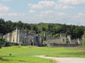 A view of castle ruins with stone walls and towers at The Old Cartshed | Yr Hen Gwt Cart in Llangernyw