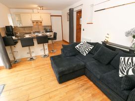 A living room with a sofa and bar stools at Red Kite Cottage in Haverfordwest