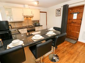 A kitchen with countertops and stools at Red Kite Cottage Haverfordwest