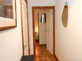 A hallway with a mirror and a door at Red Kite Cottage Haverfordwest