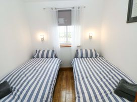 A bedroom with two single beds and a window at Red Kite Cottage Haverfordwest