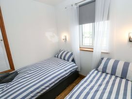 A bedroom with two beds and a window at Red Kite Cottage in Haverfordwest