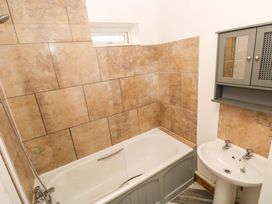 A bathroom with a bathtub and a wash basin at Red Kite Cottage Haverfordwest
