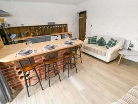 A kitchen with a counter and stools at Woodpecker in Haverfordwest