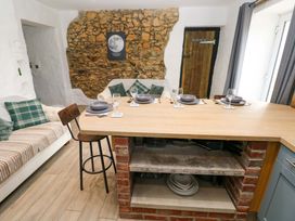 A kitchen with a dining table and stools at Woodpecker in Haverfordwest