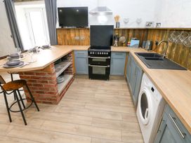 A kitchen with a stove and sink at Woodpecker in Haverfordwest