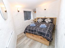 A bedroom with a bed and mirror at Woodpecker in Haverfordwest