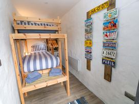 A bedroom with a bunk bed and decorative license plates at Woodpecker in Haverfordwest