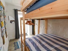 A bedroom with a bunk bed and a mirror at Woodpecker in Haverfordwest