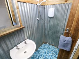 A bathroom with a shower and sink at Woodpecker in Haverfordwest
