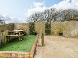 An outdoor area with wooden table and benches at Woodpecker in Haverfordwest
