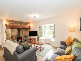 A living room with a fireplace and television at Ammerham Farm Cottage in Ammerham near Winsham