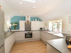 A kitchen with cabinets, oven, sink and microwave at Ammerham Farm Cottage Ammerham near Winsham