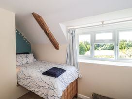 A bedroom with a bed and window overlooking the countryside at Ammerham Farm Cottage Ammerham near Winsham