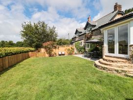 A garden with grass, trees, and patio furniture at Ammerham Farm Cottage in Ammerham near Winsham