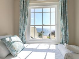 A bedroom with a window overlooking the sea at Ocean Wave in Greenhill