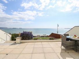 A patio area with a sea view at Ocean Wave in Greenhill