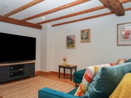 A living room with a television and sofa at Pylemoor Cottage Washfield near Tiverton