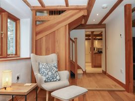 A hallway with a staircase and a chair at Pylemoor Cottage Washfield near Tiverton