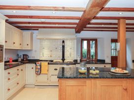 A kitchen with cabinets and a cooker at Pylemoor Cottage Washfield near Tiverton